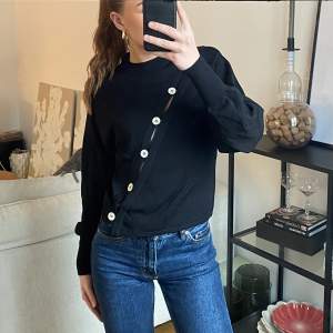 Svart ”stickad” tröja med knappar från ”Gina Lab”