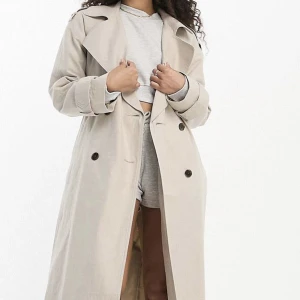 Trenchcoat i linneblandning  - Beige trenchcoat i linneblandning, passar perfekt till vår/tidig höst + sommarkvällar. Kappan är helt oanvänd, med prislappen kvar. Säljer då jag beställt fel storlek och missat returdatumet.   Foder: 100% polyester, Huvudmaterial: 65% bomull, 35% linne. 