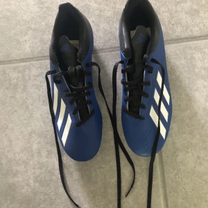 Fotbollsskor  - Ett par oanvända fotbollsskor med dobbar som aldrig kommit till användning. 