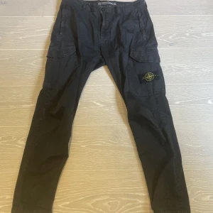 Stone Island byxor - Tja! Säljer ett par Stone Island cargobyxor i väldigt bra skick! Skick 8/10. storlek 31 passar M/L. Hör av dig vid frågor!