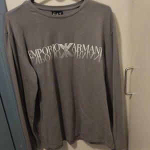 Emporio Armani långärmad t-shirt  - Långärmad t-shirt i ljusgrå färg i fint skick. Märke Emporio Armani storlek L 
