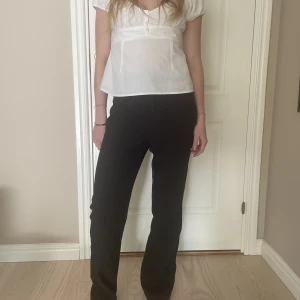 Svarta kostymbyxor  - Supersnygga svarta kostymbyxor!! Säljer då jag har andra som jag använder mer. Min syster på bilden är 168 cm lång och byxorna är lite långa på henne. Men lätt att sy upp om man vill det, annars najs med långa byxor😍