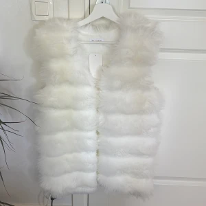 En vit fluff väst - En helt ny vitt fluff väst aldrig använd.  Storleken - s/m. Säljer för 250kr plus frakt