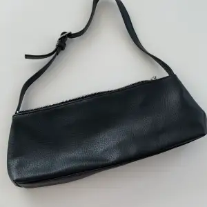 Liten och söt svart handväska från Monki. Har ett innerfack med tragkedja. Aldrig använd!