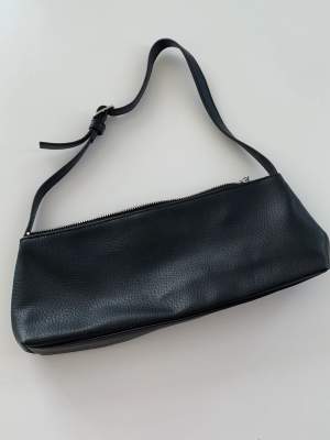 Liten och söt svart handväska från Monki. Har ett innerfack med tragkedja. Aldrig använd!