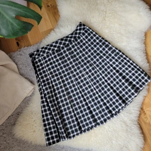 ⛓️🥀Rutig Plisserad Minikjol🖤🩶 - Plisserad minikjol med hög midja för dina kawaii looks🖤 Den är i perfekt skick utan några skador,köpt från H&M för 200kr. Själv är jag 163 cm lång och har storlek 32 på underdelar. Midjan mäts till 65 cm runt midjan och 42 cm i längd.