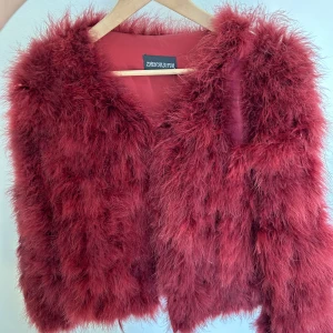 Jacka med fuskpäls  - Väldigt fin röd jacka med fuskpäls. Köp på tessie i Göteborg för några år sen, men endast använd fåtal gånger. Märket heter Zhen Hua Fur. Den är i väldigt fint skick🌸 