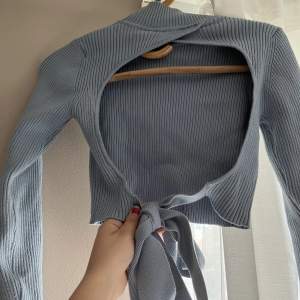 En jättefin stickad tröja med öppen rygg från zara. Den har en mer klarblå färg i verkligheten och är i bra skick. Storlek S.