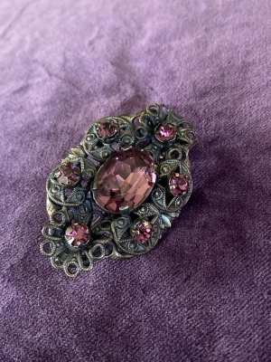 Vintage brosch  - En vacker brosch med gnistrande lila rhinestones  Okänt material   Nålen når inte stängningskorgen Behöver justeras något 