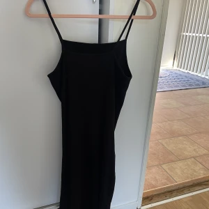 Svart klänning  - Svart klänning i över knä längd med ett litet slit nere. Använd 2-3 gånger och i bra skick!!