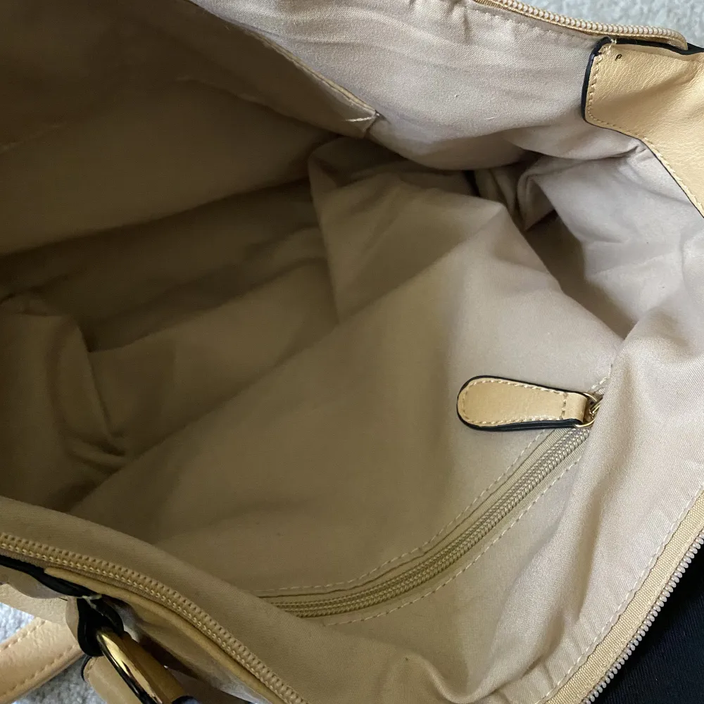 Beige väska med gulddetaljer och hängen för accessoarer 💕 Nyskick ✨Man får plats med både mappar, skoldator och vattenflaska 💕 . Väskor.