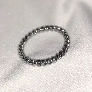 Silverfärgad ring som ser ”snurrad” ut. Är ca 2cm stor. Vikt ca 2g.