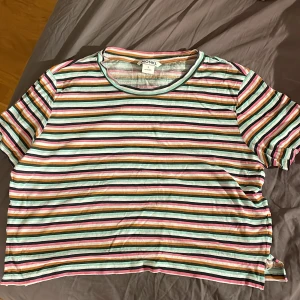 Randig croppad topp - Säljer denna färgglada randiga croppade toppen från Monki. Den är använd men i gott skick. Önskas bilder hur den sitter på så skriv<3 Storlek S, passar XS.