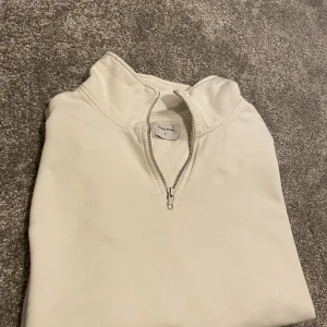Vit Half zip  - Vit half zip från studiototal. Säljer pga fel storlek. Nypris:499kr Stor i storlek. Tröjan är storlek M men den passar L. Nästan inga defekter. Lite ut tänjd. Annars 8/10