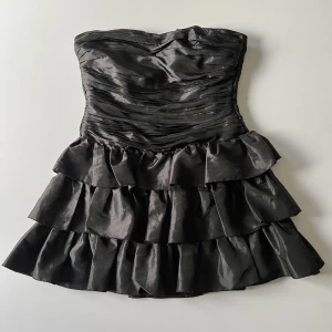 Volangklänning - Svart volangklänning med inbyggt korsett överdel från Lipsy London. Har några små hål upptill, men de smälter in så det syns knappt. Jag är 176 cm och den sitter perfekt utan att något syns 🖤