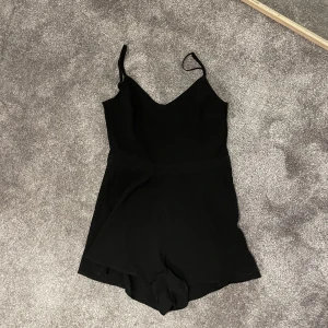 Svart jumpsuit med öppen rygg - Jätte söt svart jumpsuit med öppet hål i ryggen. Dragkedja på vänster sida av jumpsuiten. Använt ca 5 ggr. Säljer eftersom tycker den inte passar min stil längre. Köpt från H&M i storlek 36. 