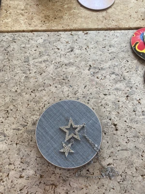 Halsband - Ett silvrigt halsband med 2 stjärnor med silvriga glasdiamanter. 💎Pris kan alltid diskuteras. ♡