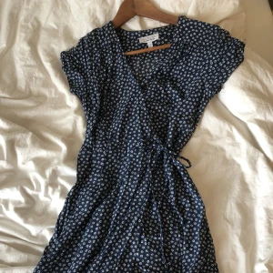 Blommig klänning - Marinblå omlottklänning med små vita blommor på. Köpt på & other stories.