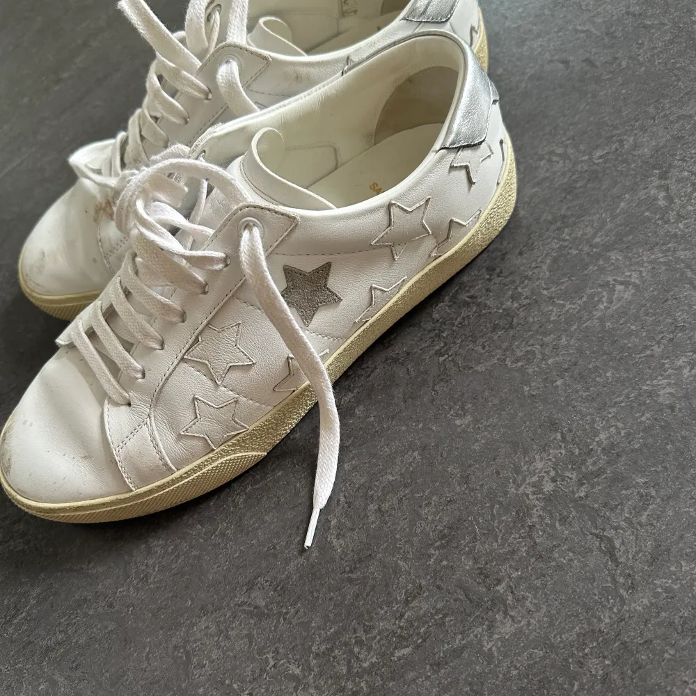 Sneakers från Saint Laurent med stjärnmönster. Har använts och har därför några märken, de är även smutsiga här och där. En del går att tvätta bort.. Skor.