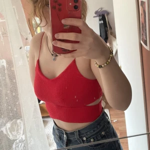 Röd crop top  - Crop top från Gina Tricot med snygga utskärningar. Passar till det mesta. Säljes pga fel storlek och kommer ej till användning. 