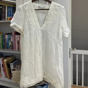 Vit klänning  - Fin klänning ifrån zara bara använd en gång😊enda nackdelen är två fula fläckar som jag tror är fläckar från någon olja eller kräm så ska få huden att se tanned och glowig ut❤️lite kort på mig (är 163) cm så kanske shorts under, har dock en lång överkropp:)