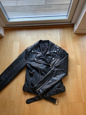 Skinnjacka  - En svart skinnjacka i storlek XS, aningen liten i storleken. Väldigt fint skick, men har dock en reva i tygen mot ryggen (se bild).  Nypris: 400 Säljer för 100kr