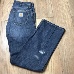 Carhartt Jeans - Snygga Carhartt Jeans med lite färg på  Inte helt 100 på vilken storlek med skulle gissa på 27x30