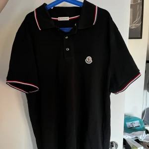 Moncler piké  - En fin moncler piké i färgen svart. Används inte då den är lite för liten för mig. Riktigt snygg och perfekt inför sommaren🤩 skriv vid intresse eller flera bilder!