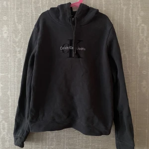 Svart hoodie | Calvin Klein - En jättefin äkta svart Calvin Klein hoodie. På lappen står det storlek M, men jag skulle säga att den passar bättre på någon med XS eller S. Den är ej strechig. Säljer då den ej är min stil längre. Skriv för mer info och bilder.