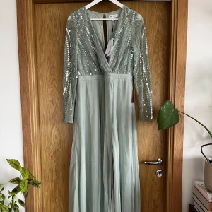 Salviagrön festklänning 42 - Frock and frill, storlek 42. Superfin men för stor för mig 🥺 köparen betalar frakt! 