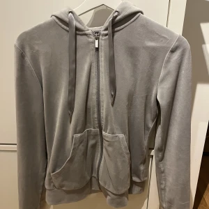 Zip-up hoodie - En fin, ljusgrå zip-up hoodie i sammet från Gina. Dem är i fint skick!