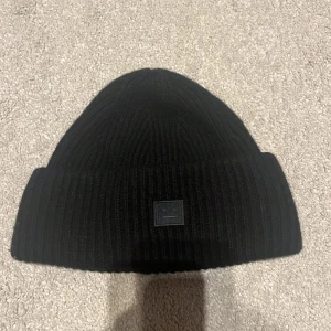 Svart Acne mössa - Jag säljer min acne mössa. Den var köpt i februari 2023, den är nästan oanvänd och är i super bra skick! Inga hål eller fläckar. 