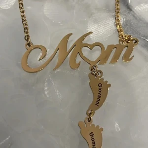 Halsband med namn. - Guldfärgat halsband där de där plats två st namn i fötter som du väljer själv.  15% rabatt vid köp av fler annonser.  Samfraktar.