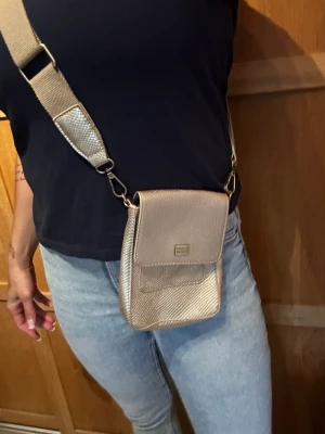 Bazar väska  - En perfekt mindre väska för mobil mm i guld. Använd 2ggr som ny! 