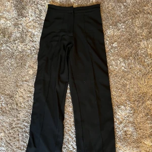 Kostymbyxor  - Svarta kostymbyxor med gul/grön/vit rand. Stl XS, passar mig som har stl S