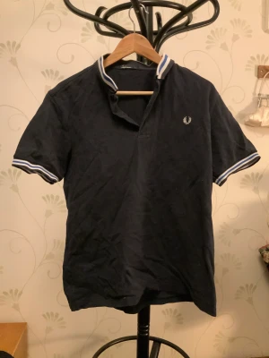 Fred Perry piké  - Snygg piké av Fred Perry som inte kommer till användning. Bra skick förutom små hål som syns i bild 3.  