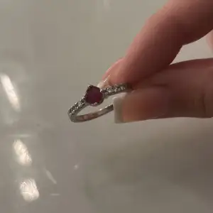 En ring i äkta silver med en röd Sten på. Helt oanvänd. Storlek 18. Kan skicka lite bättre bilder privat 