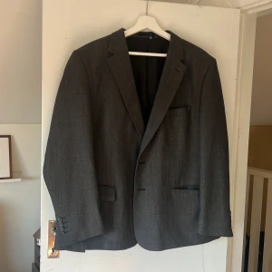 Kavaj  - Grå kavaj. Köpt second hand men skulle säga att den är storlek L/XL. I bra skick. Axelpuffar.