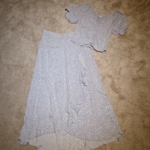 Top och kjol blommig barn  - Blåblommig vadlång kjol med volang, och croppad top. Nyskick.