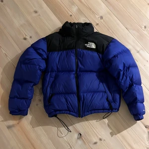 North face jacka 1996 Retro Nuptse - Säljer nu min ytterst fina North face jacka! Endast använd under förra vintern och är i toppenskick. Färgen på den är blå/lila men klarblå i tydligt ljus (bild 3). Nypris ligger på ca 4000. Jag är 184 och den passar super. Tveka inte på att höra av er!😁