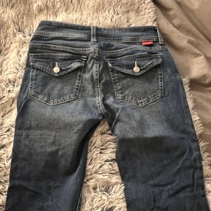 Low waist jeans med fickor💙 - Säljer dessa as snygga mörkblåa jeansen med fickor. Dem är lågmidjade och flared. Säljer dessa då jag inte använder dem. Väldigt fint skick som nya. Str 36💙