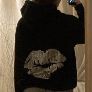 Rihnstone hoodie - Svart hoodie med tryck på ryggen i form av läppar som jag har satt på själv. Trycket går inte bort i tvätten