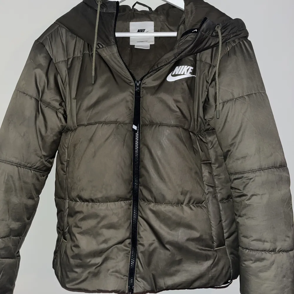 Nike Sportswear Therma Fit Repel  Puffer Jacket i fortfarande bra skick som är köpt från Junkyard. Längden är medel och har detaljer nedtill och i luvan. Nypriset är 1500 kr.. Jackor.