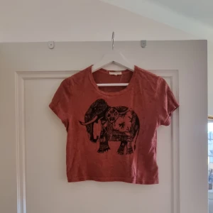 T-shirt  - T-shirt med tryck av en elefant på. Väldigt lätt material. Jag passar personligen inte i röd säljer därför