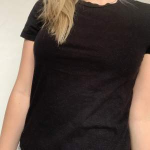 En svart t-shirt som har lite glitter på sig, använd få gånger men tröjan är i bra skick🩷