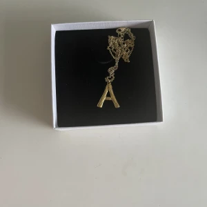 A halsband - Halsband från Safira med ett A på, som nytt och smyckesasken finns kvar och skickas med vid köp. Köpare står för frakt 