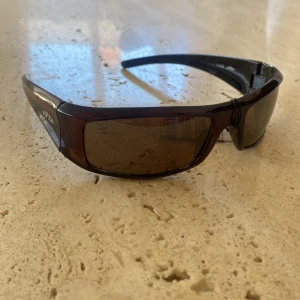 Solglasögon  - Mörk bruna solglasögon med brunt glas. Aldrig använda!