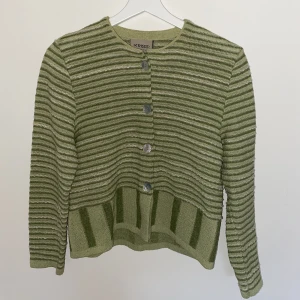 Stickad kofta  - Sötaste stickade koftan från Kriss. Snygg både knäppt och uppknäppt i en härlig grön färg 