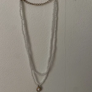 Pärlhalsband Emmiol  - Fint pärhalsband med berlock från Emmiol! Knappt använd, bra skick. 