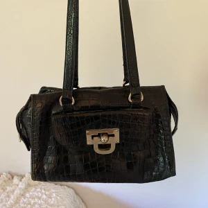 Vintage DKNY väska  - Säljer denna snygga vintage väska från DKNY, den rymmer mycket o har flera olika fack. Lite slitage på botten (se sista bilden), skriv för fler bilder 